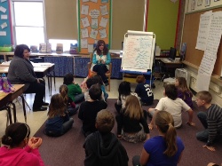 author reading to students sitting on carpet