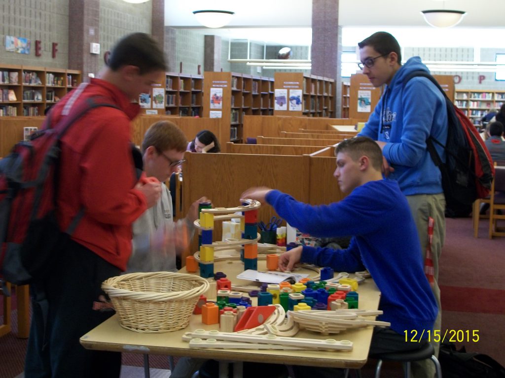three students making paper plains