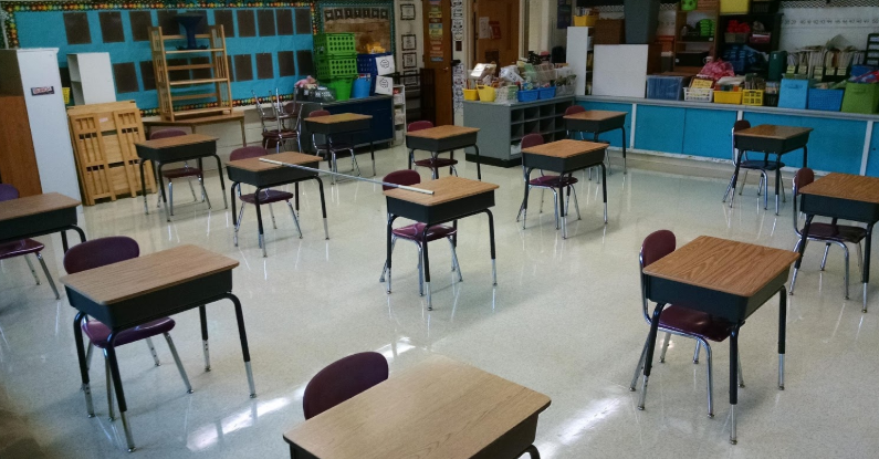 Classroom set up with individual desks at least six feet apart