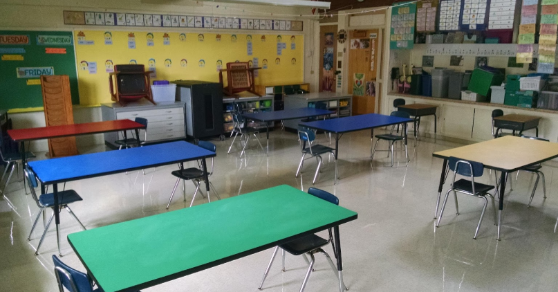 Classroom set up with tables, chairs on each end of the tables facing each other.