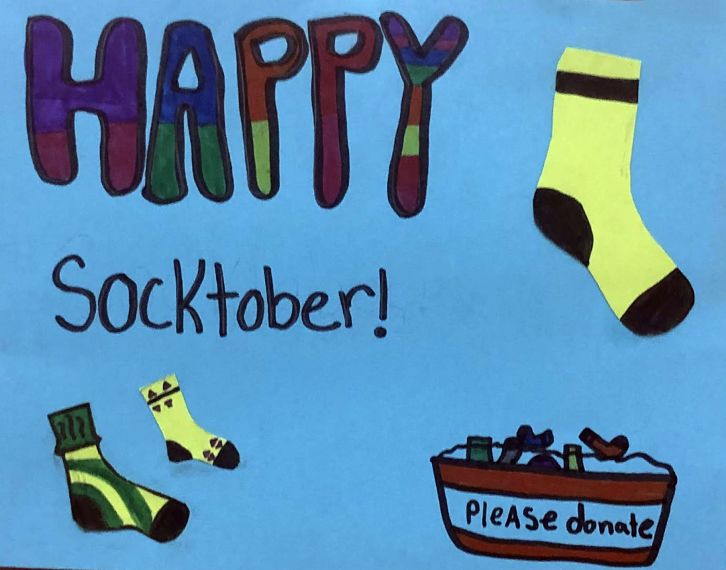 Sign created by students at GES for Socktober donation bins. "Happy Socktober! Please donate."