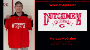 Student athlete Marcus McClaine smiles for the camera holding a red Dutchmen shirt with white lettering.