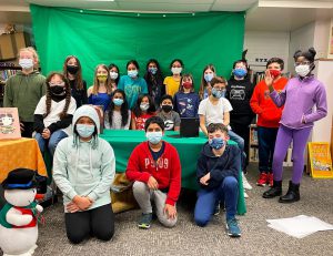 Image of Westmere students posing in front of library green screen studio