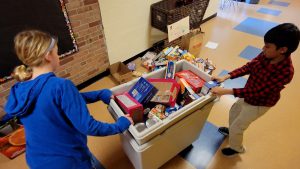 Two students collect food items donated by the Guilderland Elementary community.
