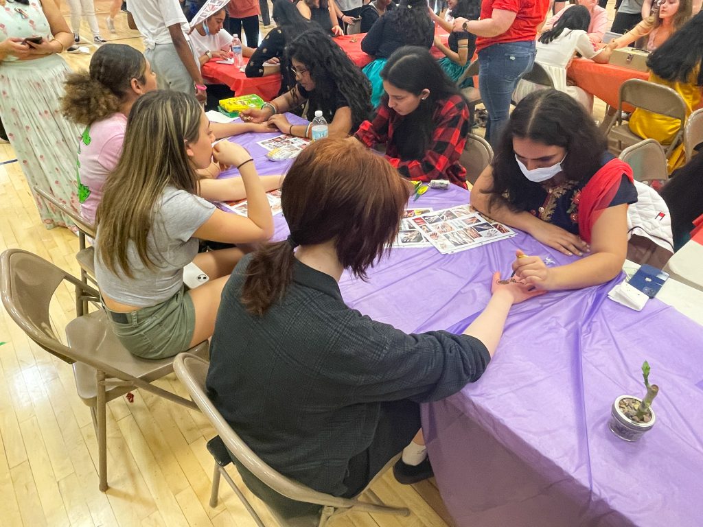 Three GHS students are getting henna art done on their hands.