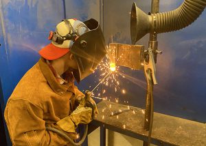 CTE student welding, with sparks flying.