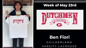 Ben Fiori Dutchmen of the Week for May 23. He's standing and holding a tee shirt as he smiles at the camera.