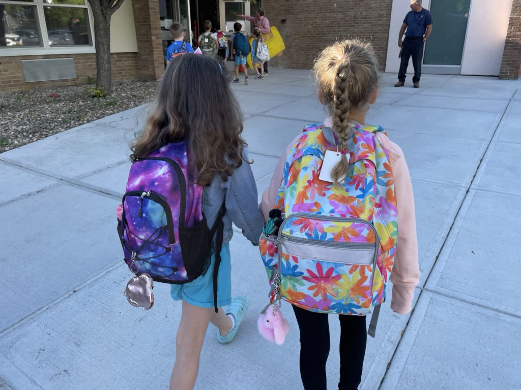 Two AES students walking into building after walking school bus