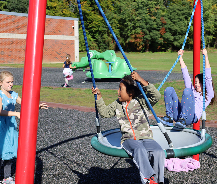 PBES students on playground swings.