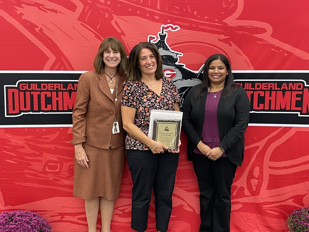 District superintendent and Board of Education president posing for a photo with an award recipient.