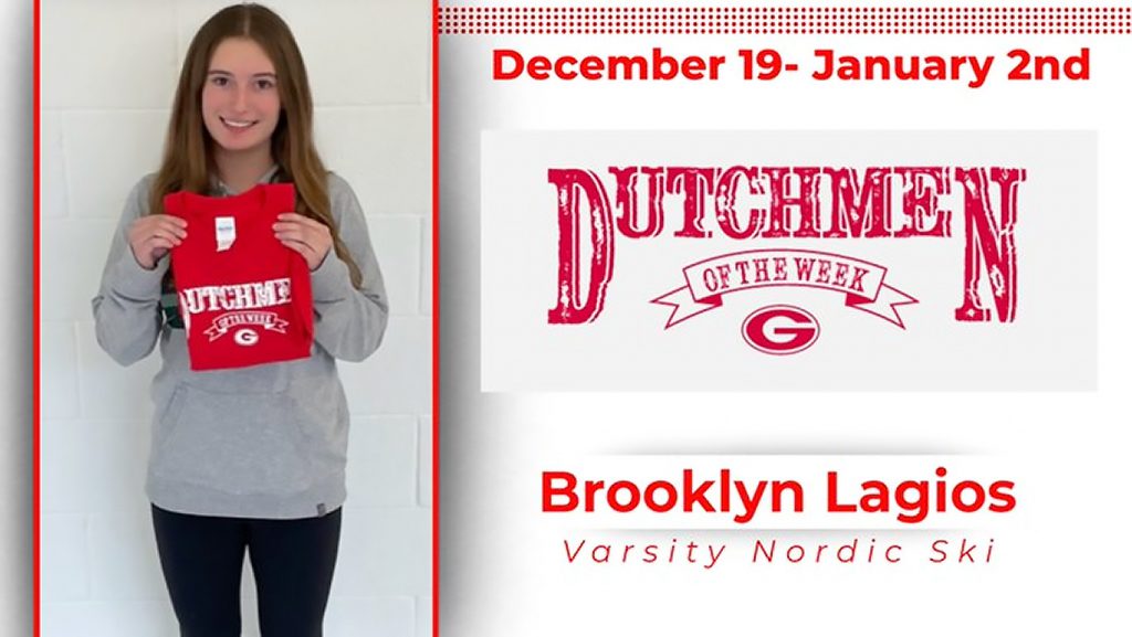 Student holding red t-shirt, smiling