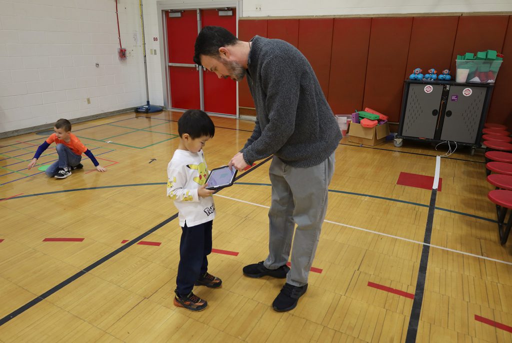 Teacher showing his student something on an iPad.