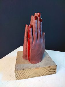 Sculpture of hands with palms together.