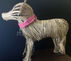 Dog sculpture made out of basket wicker.