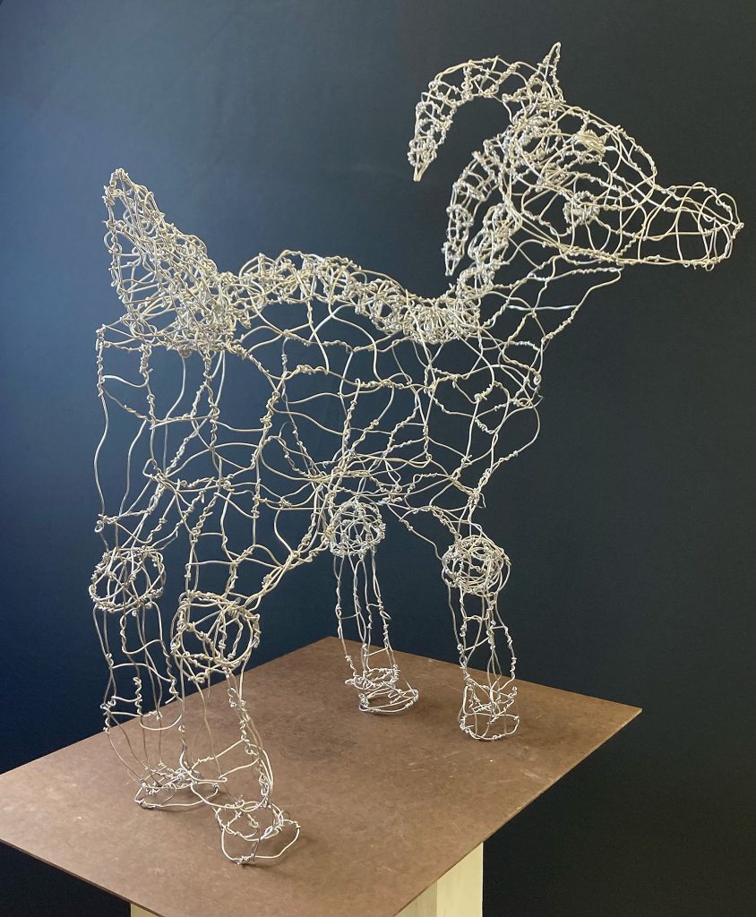 Sculpture of a goat made out of wire.