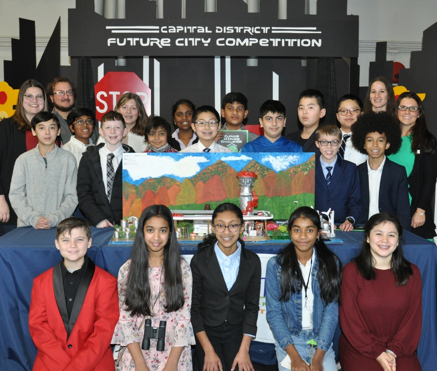 FMS Future Cities team poses around its model city design and poses for picture.