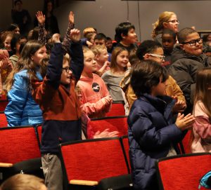 Students react enthusiastically in the audience of the Young People's Concert.