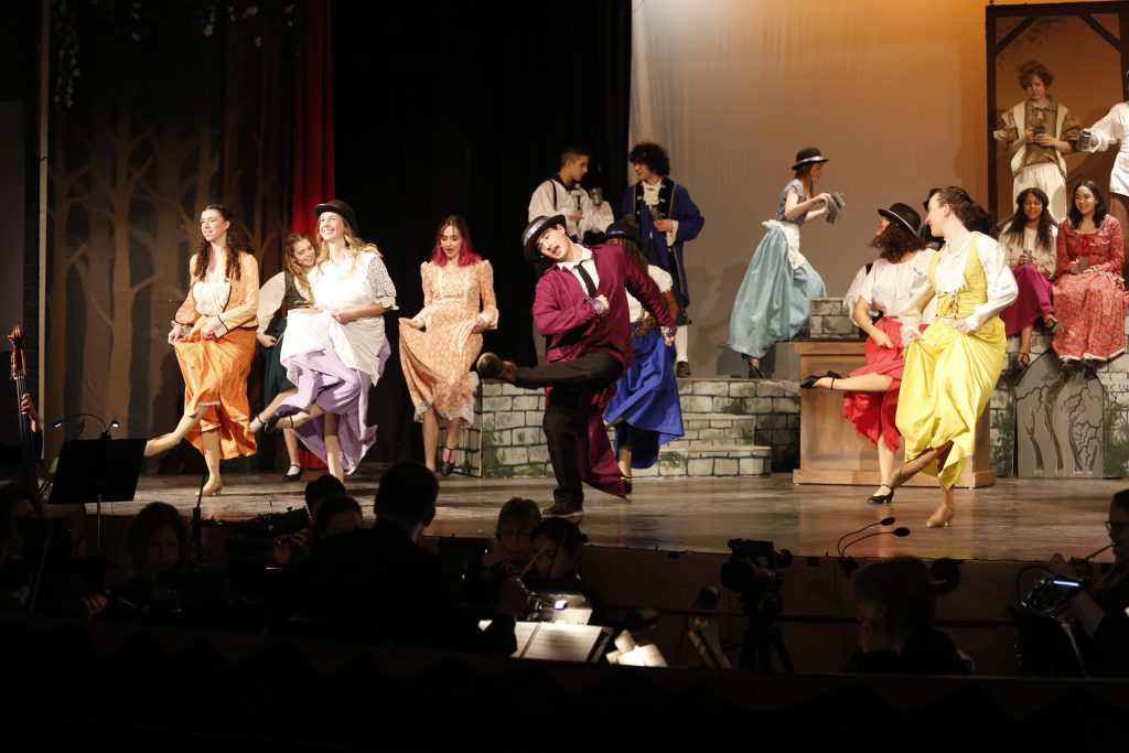 A group of students sing and dance during Beauty and the Beast
