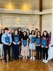 A group of students stand with GHS Principal holding certificates they received.
