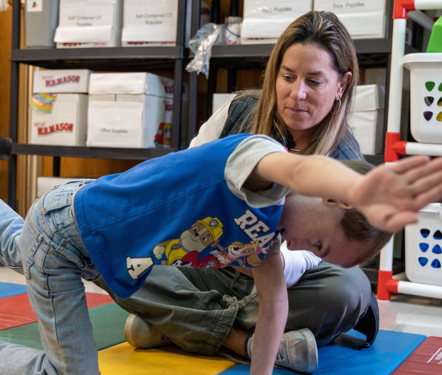 Student learns a new exercise from the school physical therapist