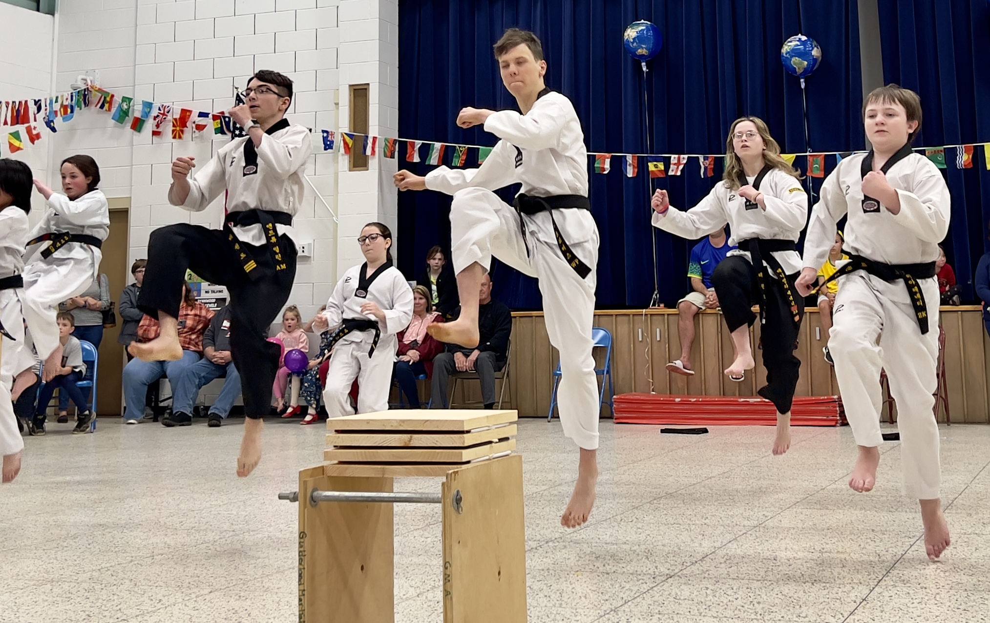 A group of people wearing white traditional clothes perform jujitsu at the LES International Night event.