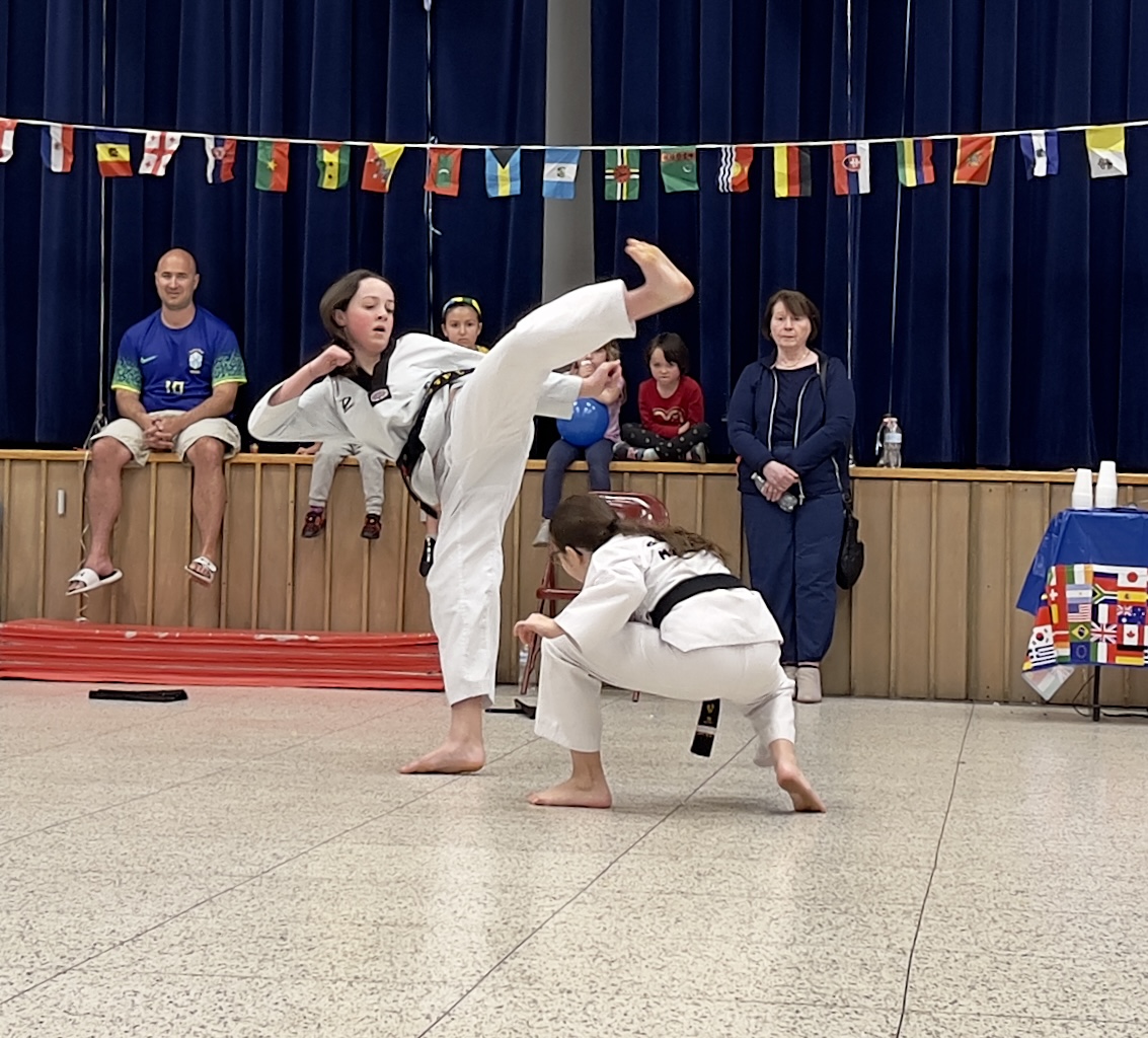 Two people wearing white traditional clothes perform jujitsu at the LES International Night event.