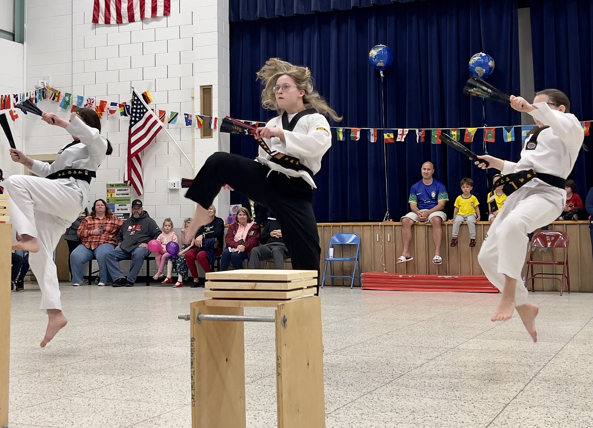Three people wearing white traditional clothes perform jujitsu at the LES International Night event.