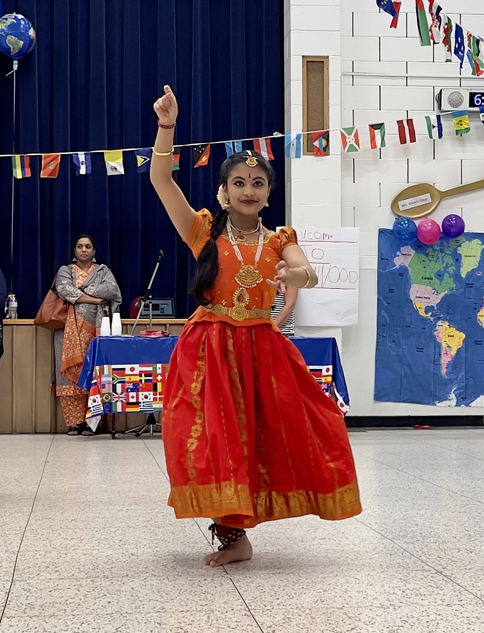 One LES student wearing brightly colored traditional clothes from their culture dances in the LES gym at the International Night event.