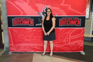 Woman standing in front of the Guilderland photo backdrop.