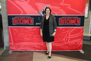 Woman standing in front of the Guilderland photo backdrop.