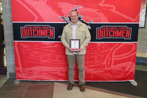 Man standing in front of the Guilderland photo backdrop.