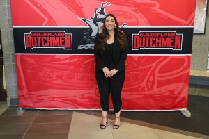 Woman standing in front of the Guilderland photo backdrop.