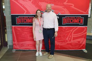 Woman and man standing in front of the Guilderland photo backdrop.