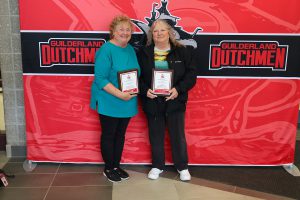 Two women standing in front of the Guilderland photo backdrop.