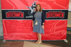 Woman standing in front of the Guilderland photo backdrop.