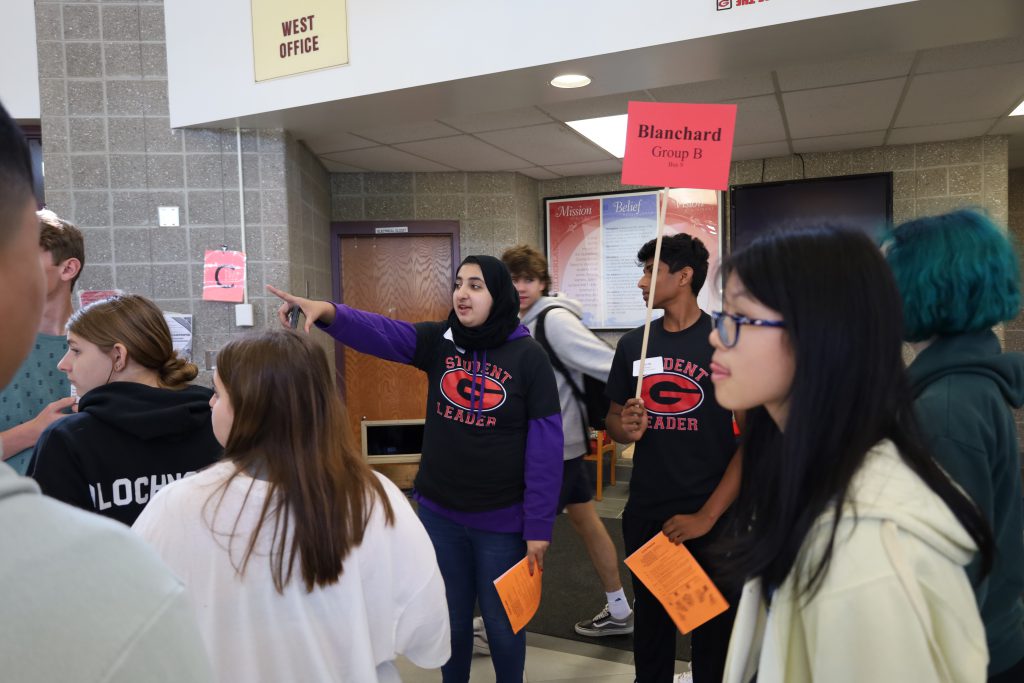 Students stand in the high school hallway while touring the building.