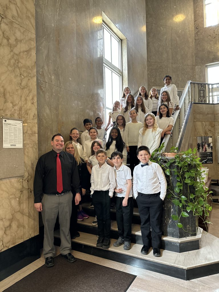 The PBES select chorus stands on a staircase in the U.S. federal courthouse. With them are two teachers.