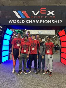 A group of students wearing red t-shirts stand in front of the entrance to the Vex Robotics World Championship venue