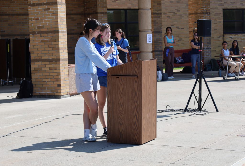 Two students speaking at podium.