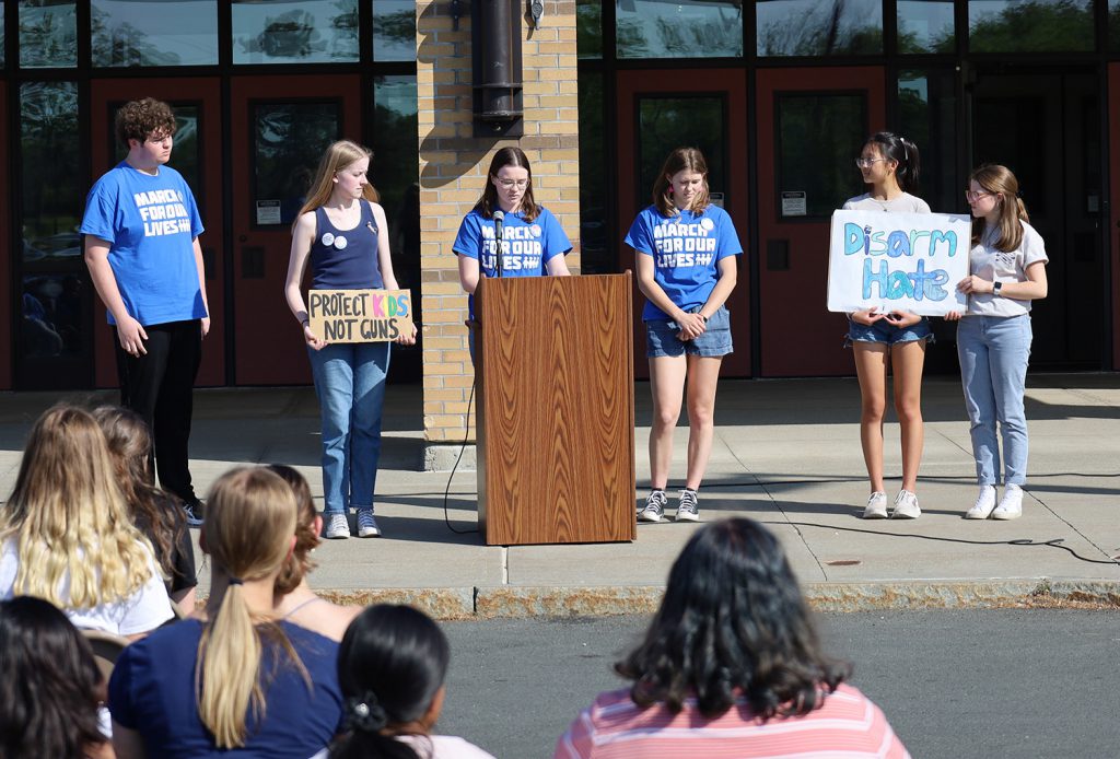 A group of students conducting a presentation at the podium.