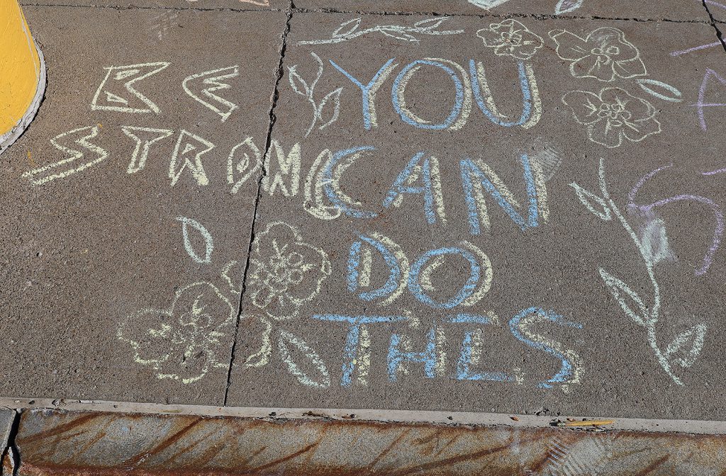"You can do this" and "be strong" written in chalk on a sidewalk.