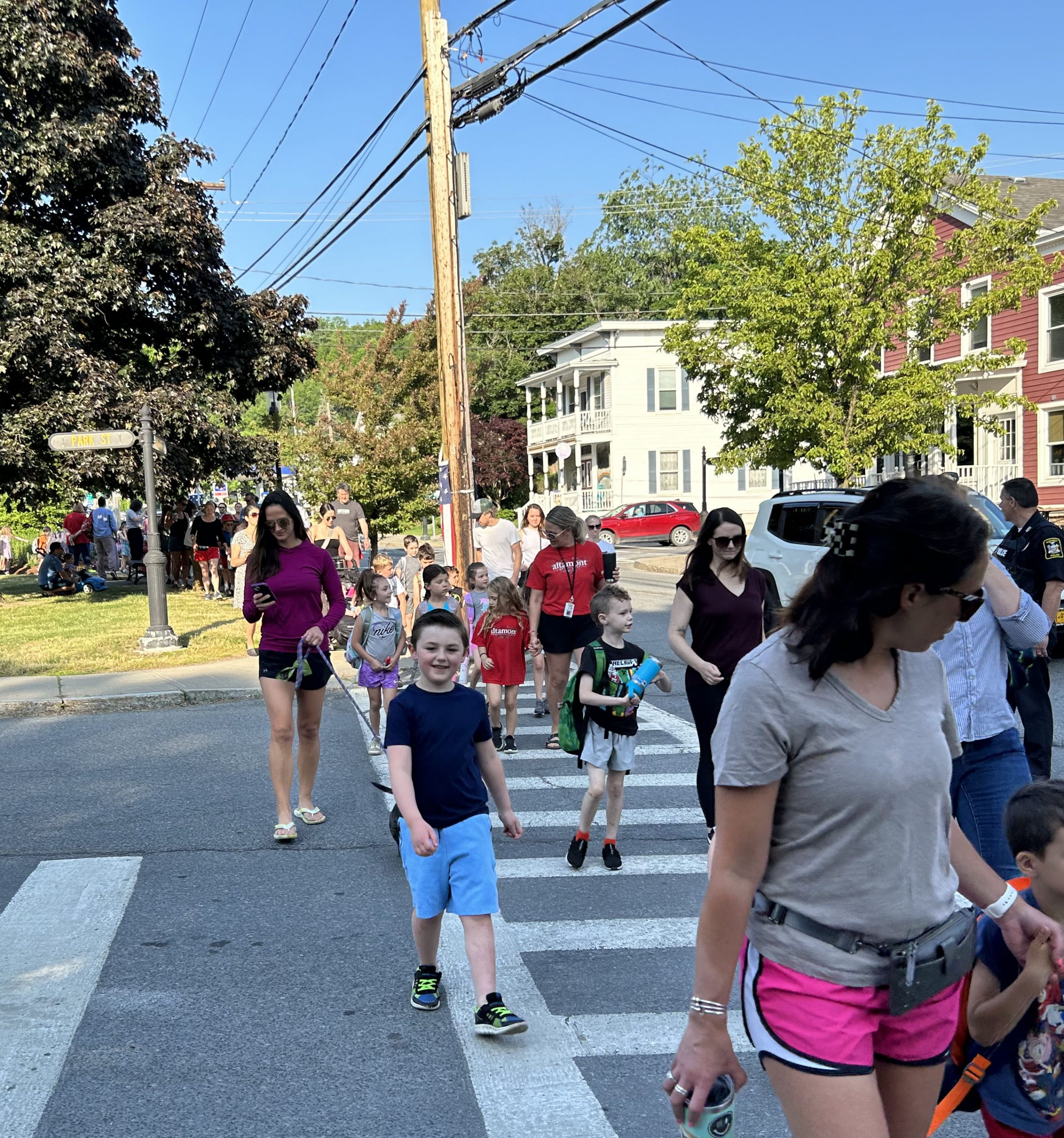 Student looks at camera and smiles while walking with others to school.