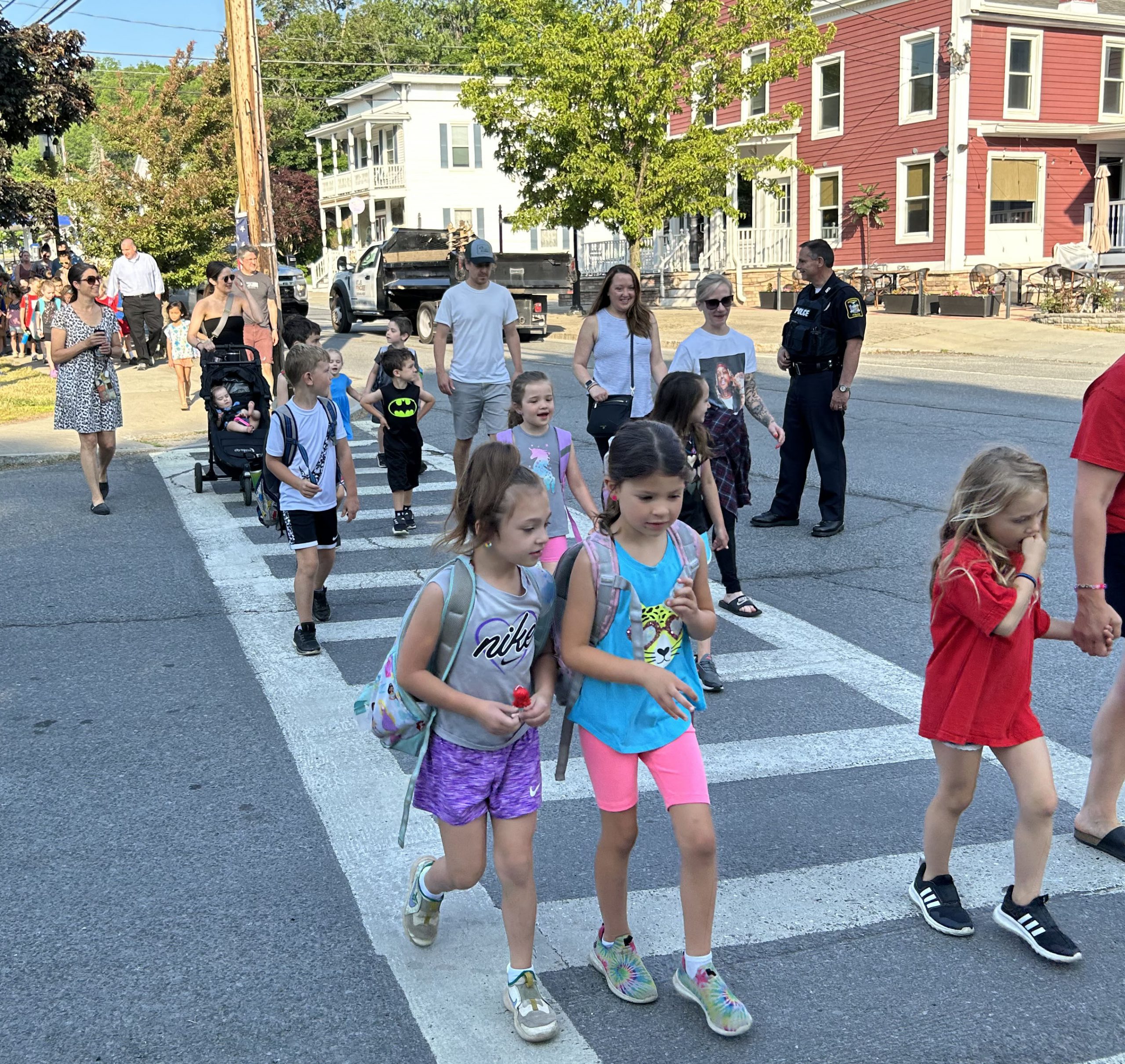 Students cross a street while walking to school