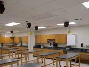 Image of science classroom. Movable desks/lab tables, cabinets against the wall