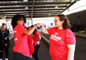 Two students fist bump and smile at each other