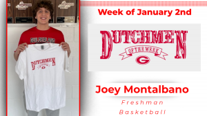 A student stands against a white wall holding a white t-shirt with red text that reads Dutchmen of the Week