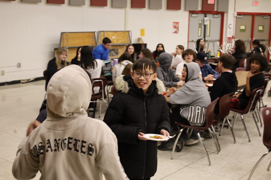 Student smiling towards another student.