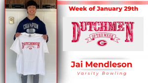 A student stands holding a white t-shirt with red lettering that reads: Dutchmen of the Week