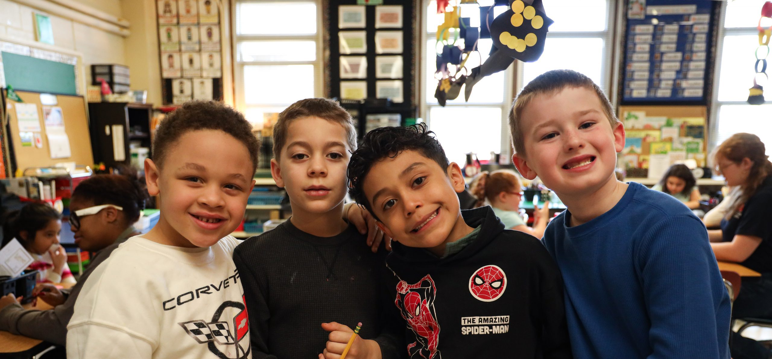 Four elementary students smiling at the camera.