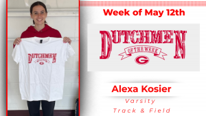 A student stands in front of a white wall, holding a white t-shirt with red lettering that reads "Dutchmen of the Week."